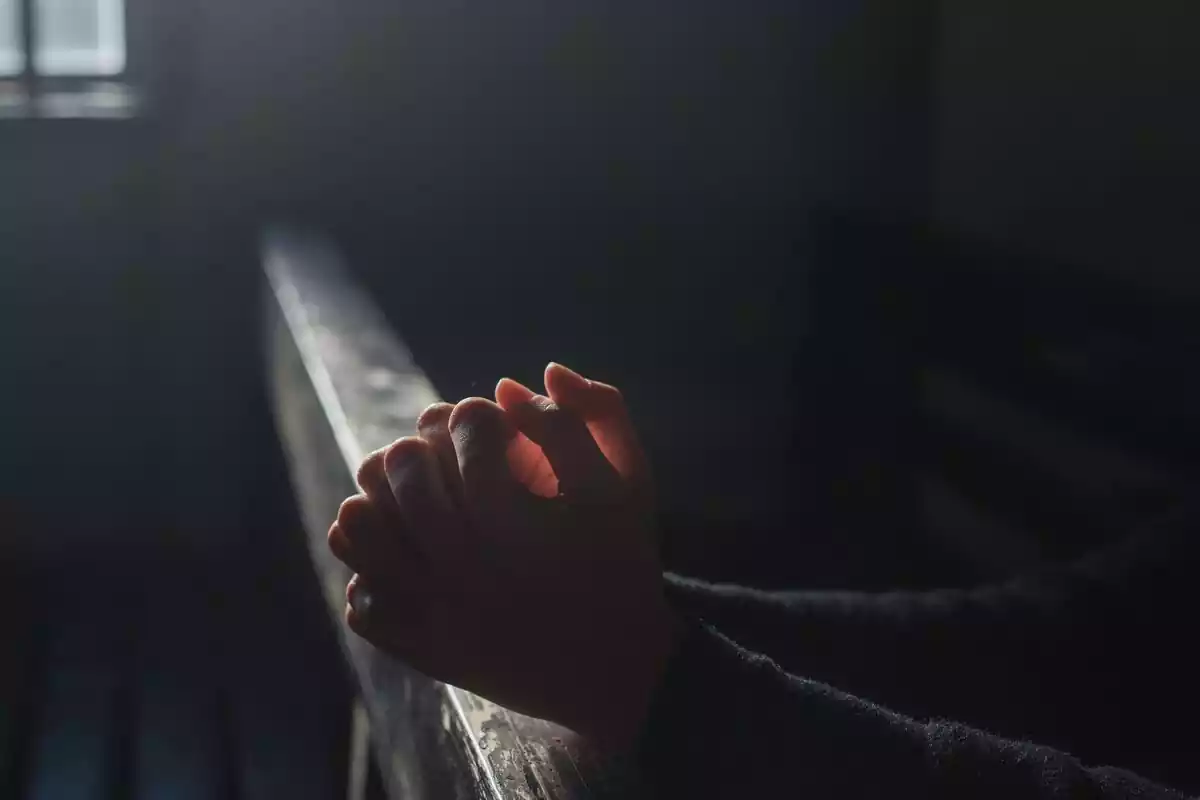 Manos de una persona rezando