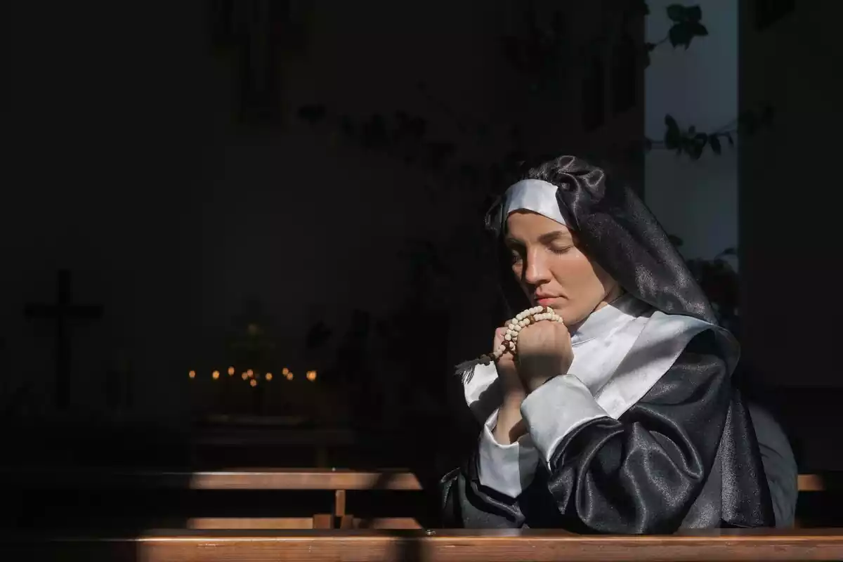 Monja rezando en la iglesia
